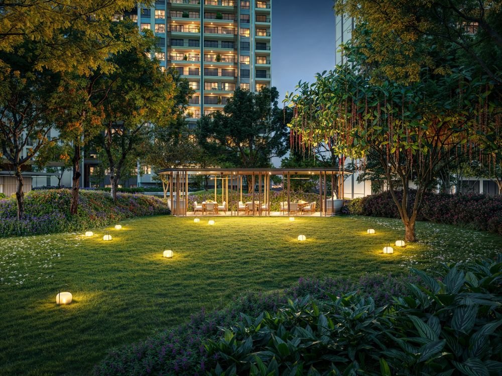 Lawn with lanterns and a dining pavilion below the Condovilla towers at dusk